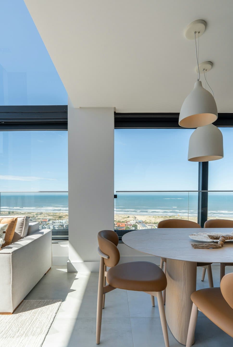 Nowoczesny salon w apartamencie z widokiem na ocean i nadmorskie miasteczko.